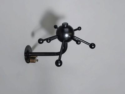 un petit objet noir accroché au mur, à côté d'une lampe