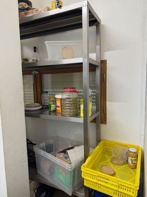 un panier jaune posé à côté d'une étagère en métal dans une cuisine