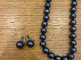 a close up of a necklace and earring on a table