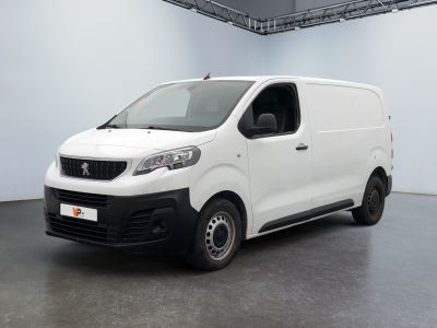 La petite camionnette blanche est garée dans une grande pièce.