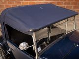 a blue car parked in front of a brick wall