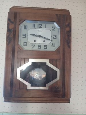 une horloge en bois accrochée au mur d'une pièce