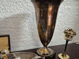 a table with silverware and a silver vase on it