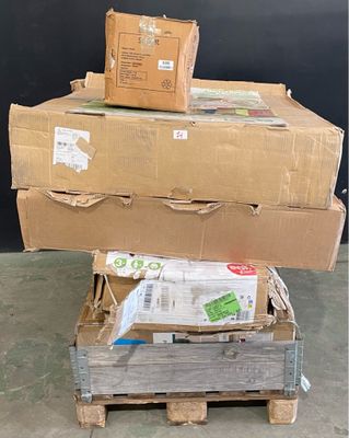 des cartons empilés les uns sur les autres sur une palette devant un mur noir