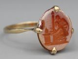 an image of a gold ring with a red stone in the center