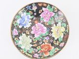 une petite assiette décorée de fleurs, posée sur un fond blanc