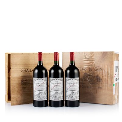 trois bouteilles de vin rouge dans un coffret en bois posé sur une surface blanche