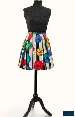 une robe posée sur un mannequin, avec un haut noir et des fleurs colorées