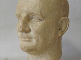 a stone head of a man on a white surface