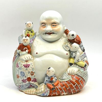 une figurine représentant un Bouddha souriant assis sur un coussin