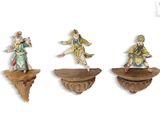 trois figurines représentant un homme et une femme, posées sur une étagère