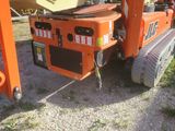 a small orange machine that is parked in the dirt