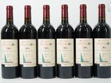 six bouteilles de vin sont alignées sur une surface blanche