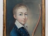 portrait d'un jeune garçon en costume bleu, avec un nœud papillon, dans un cadre doré
