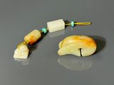 pair of carved bone beads with turquoise beads on a gray surface