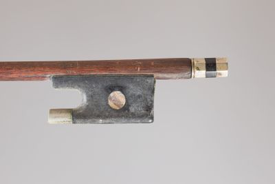 un vieil archet de violon dont l'extrémité est surmontée d'un morceau de bois