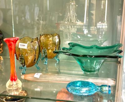 une vitrine en verre remplie de vases de différentes couleurs