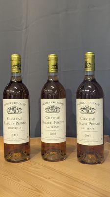 trois bouteilles de vin sont posées sur une table en bois devant un mur bleu