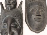 several african masks are displayed on a white surface