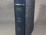 an old blue book with a cross on it sitting on a table