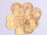 a pile of gold coins sitting on a white surface