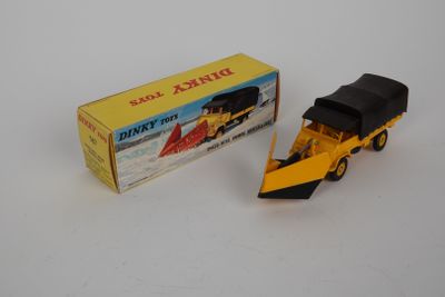 un camion jouet jaune avec une cabine noire, à côté d'une caisse