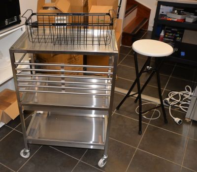 a metal cart with a basket on top of it
