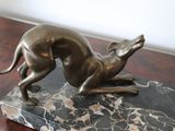 a bronze statue of a dog on a marble base