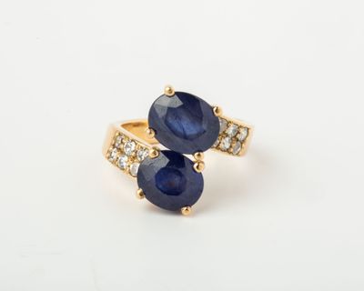 gros plan d'une bague en saphir bleu et diamant sur une surface blanche