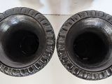 two black vases sitting on a white table