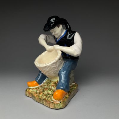 porcelain figurine of a man with a drum and oranges