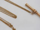 an image of a gold necklace with a telescope on a chain