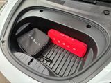 a red suitcase sitting in the trunk of a car