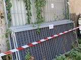 une clôture qui a été renversée et sur laquelle est enroulé un ruban rouge et blanc