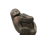 statue d'un homme assis sur une chaise, de dos à la caméra