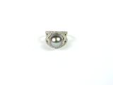 gros plan d'une bague en perles et diamants sur une surface blanche