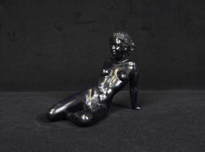 statue of a woman sitting on her stomach on a black background