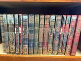 many books that are on a shelf in the library