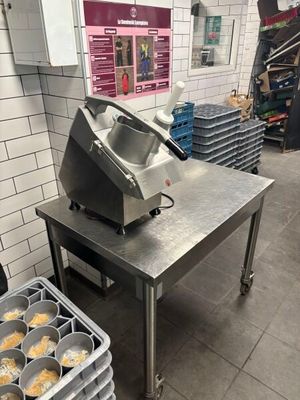 Plusieurs plateaux de muffins sont posés sur une table dans une cuisine