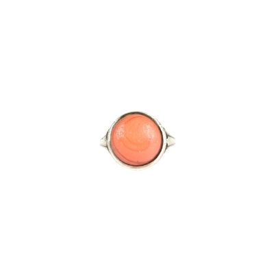 Gros plan sur une bague contenant une pierre orange