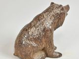 a brown bear figurine sitting on a white surface