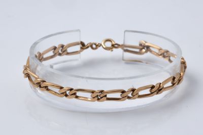 un gros plan d'un bracelet transparent et doré posé sur une surface blanche