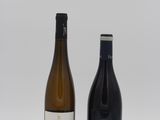 two bottles of wine sitting next to each other on a white surface