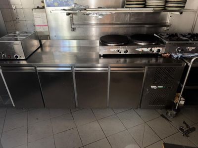 une cuisine équipée de plans de travail et d'appareils électroménagers en acier inoxydable