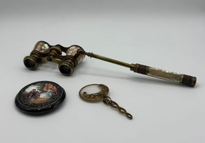 un petit télescope et une montre de poche posés sur une table