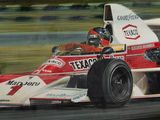 un tableau représentant un homme au volant d'une voiture de course sur un circuit