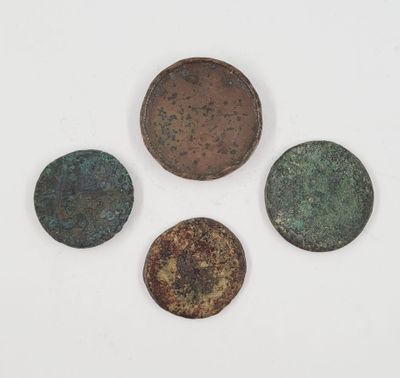 a group of four bronze coins sitting on top of a white surface