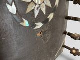 a close up of a metal object with a sun design on it