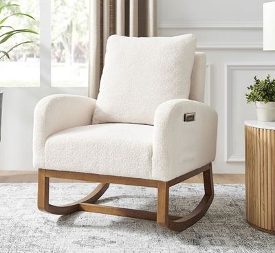 un fauteuil à bascule blanc posé sur un tapis, à côté d'une lampe