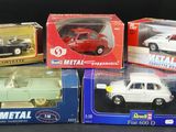 three boxed models of toy cars in boxes on a black surface